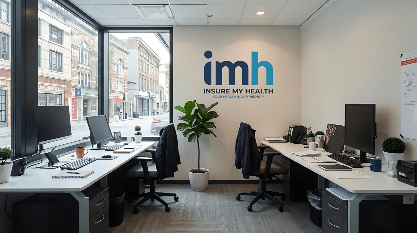 IMH OFFICE Modern office with two desks, computers, and office chairs, large windows overlooking a city street, a potted plant, and a wall sign reading “imh INSURE MY HEALTH—private health insurance UK: YOUR HEALTH IS OUR PRIORITY.”.